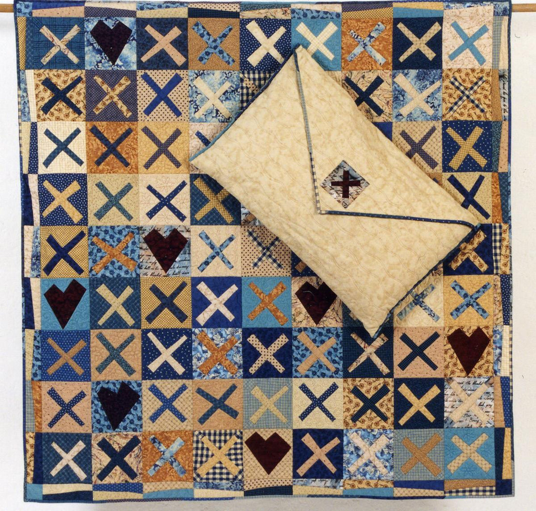 patterned quilt with hearts and kisses. a sewn envelope sits on top