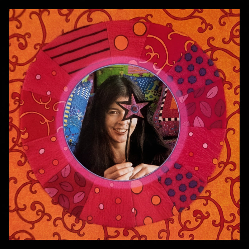 Jan Mullen holding a colorful star-shaped mirror with a vibrant, patterned background